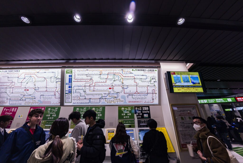 Commuters viewing a detailed train route map at the new Harajuku station.