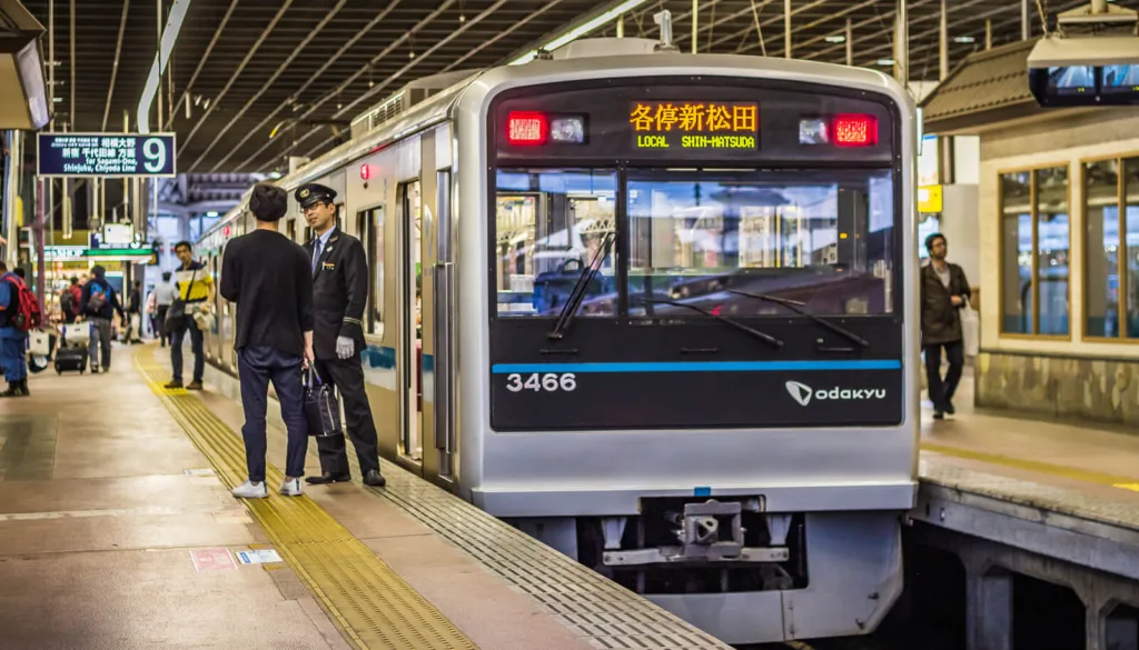 Train at Hakone Yumoto station with passengers on the platform.