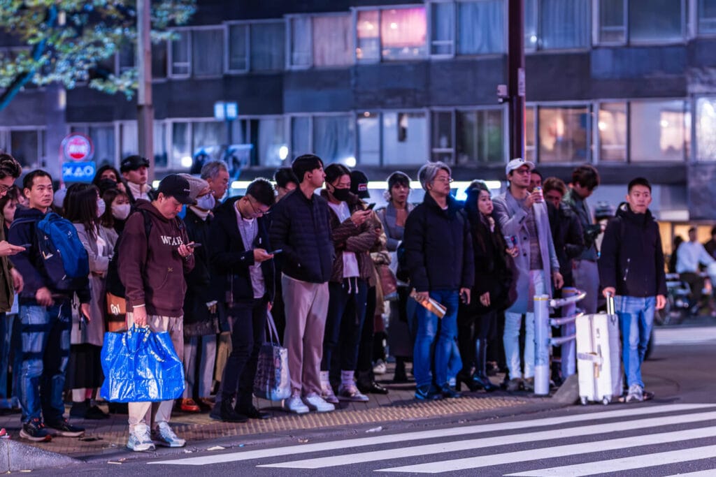 People ready to cross the street at a red light crossing at Harajuku.