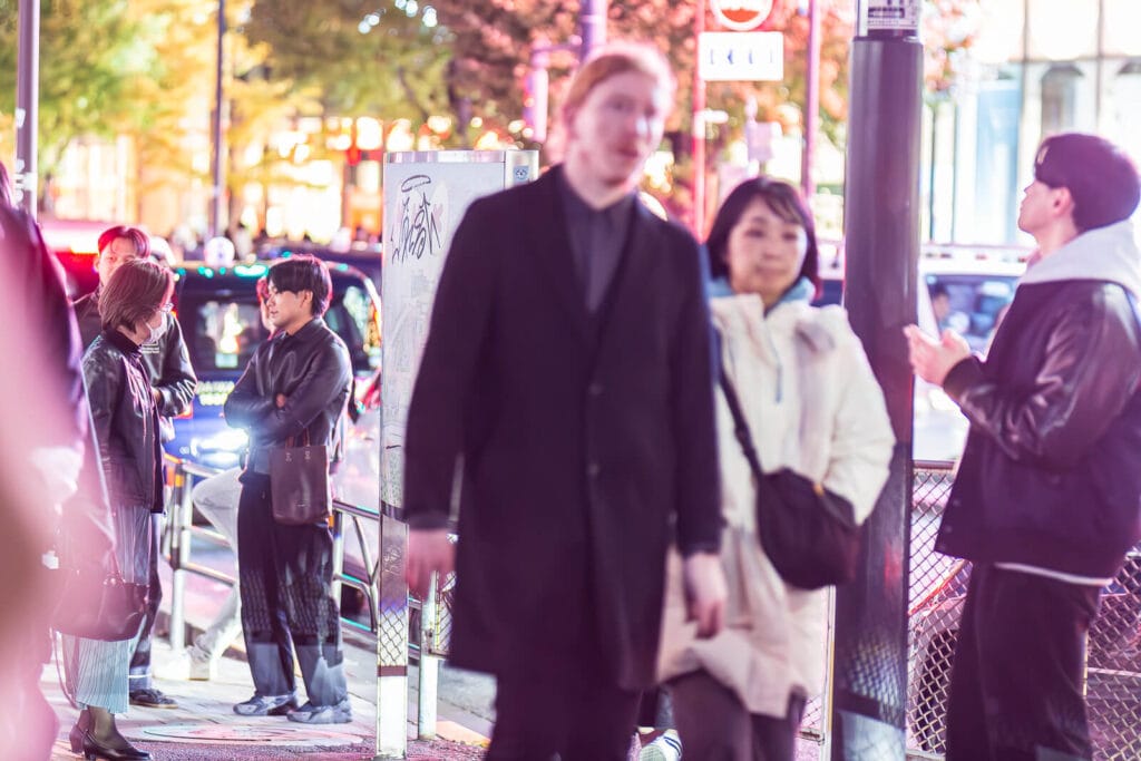 People conversing on the sidewalks of Harajuku street.