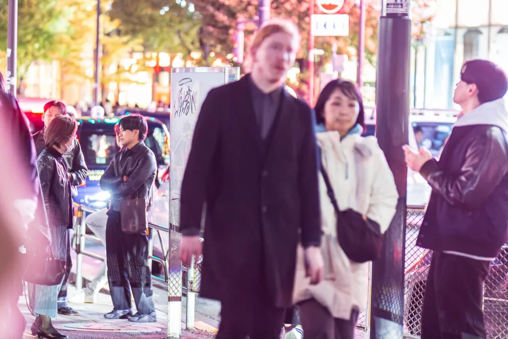 People conversing on the sidewalks of Harajuku street.