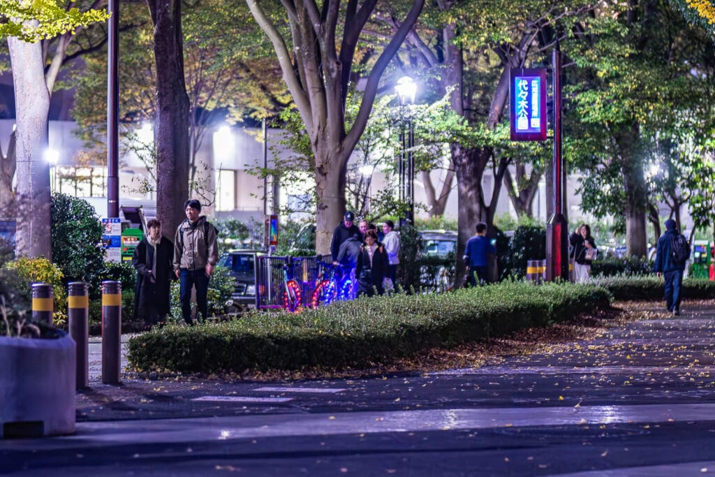 People walking on the sidewalks at Harajuku near Yoyogi Park.