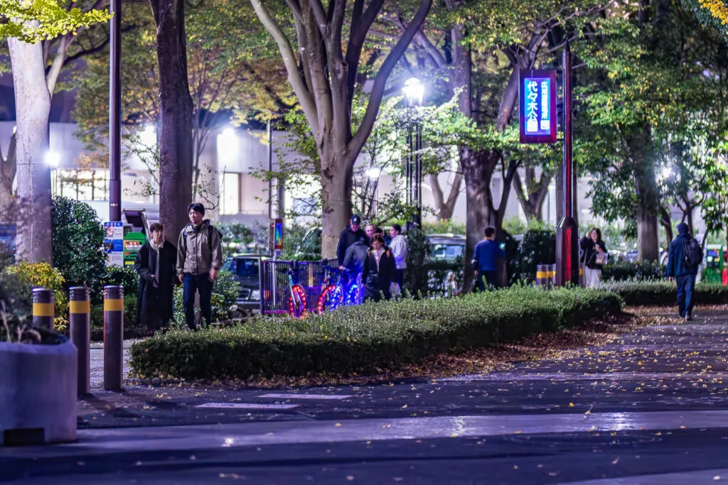 People walking on the sidewalks at Harajuku near Yoyogi Park.