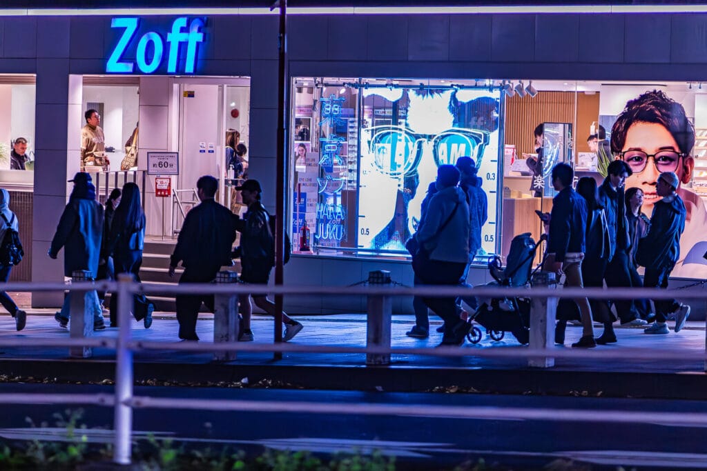 People walking on a sidewalk at Omotesando street in Harajuku.
