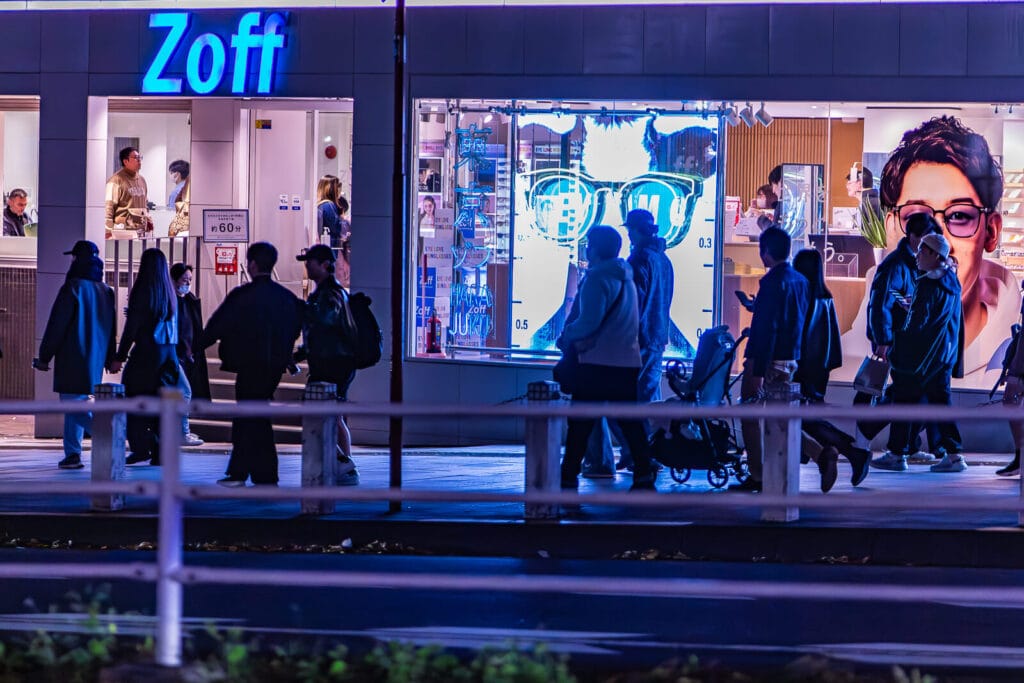 People walking on a sidewalk at Omotesando street in Harajuku.