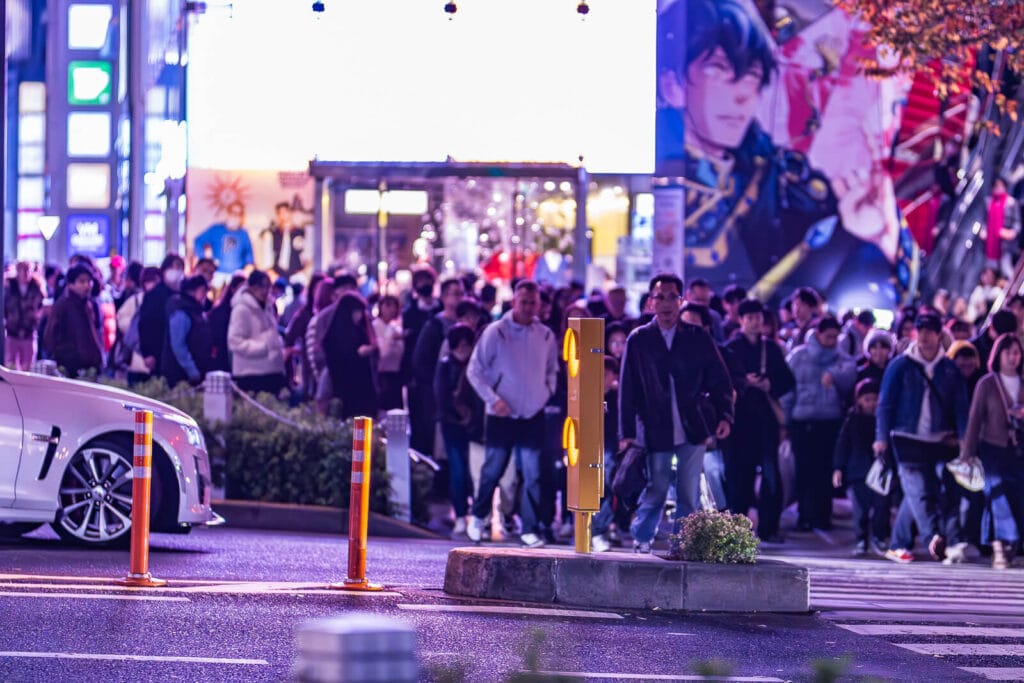 people waiting to cross the street in front of Tokyu Plaza Omotesando
