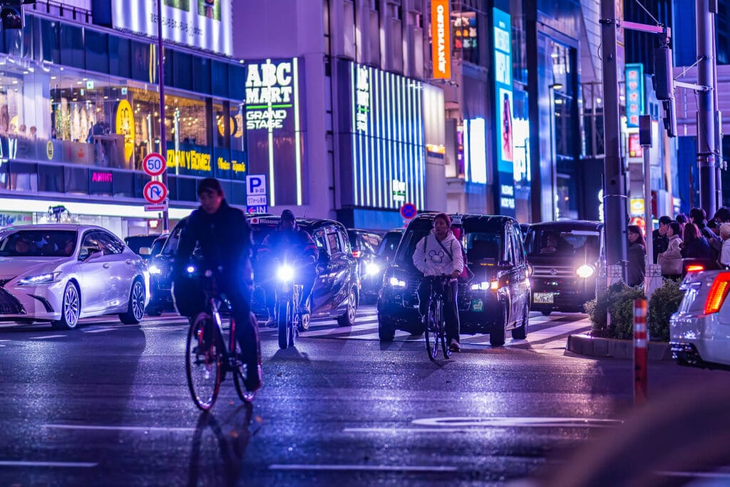 Cyclists and cars on Harajuku street.