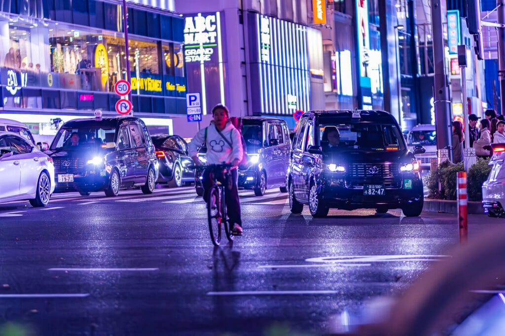 Cyclists and cars on Harajuku street.