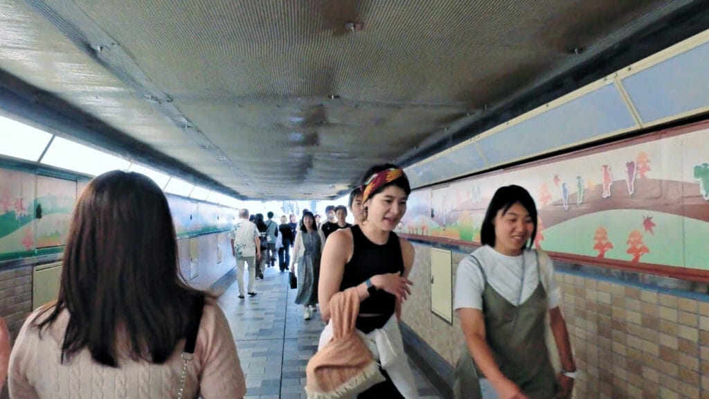 People going through tunnel under Shinjuku o-guard