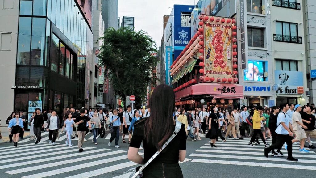 People crossing the road at a Shinjuku crossing near Cat Bilboard.