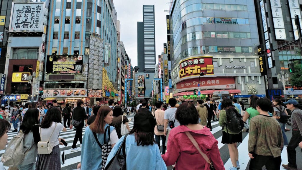People walking at Kabukicho Shinjuku in the evening. You can see the Godzilla head.