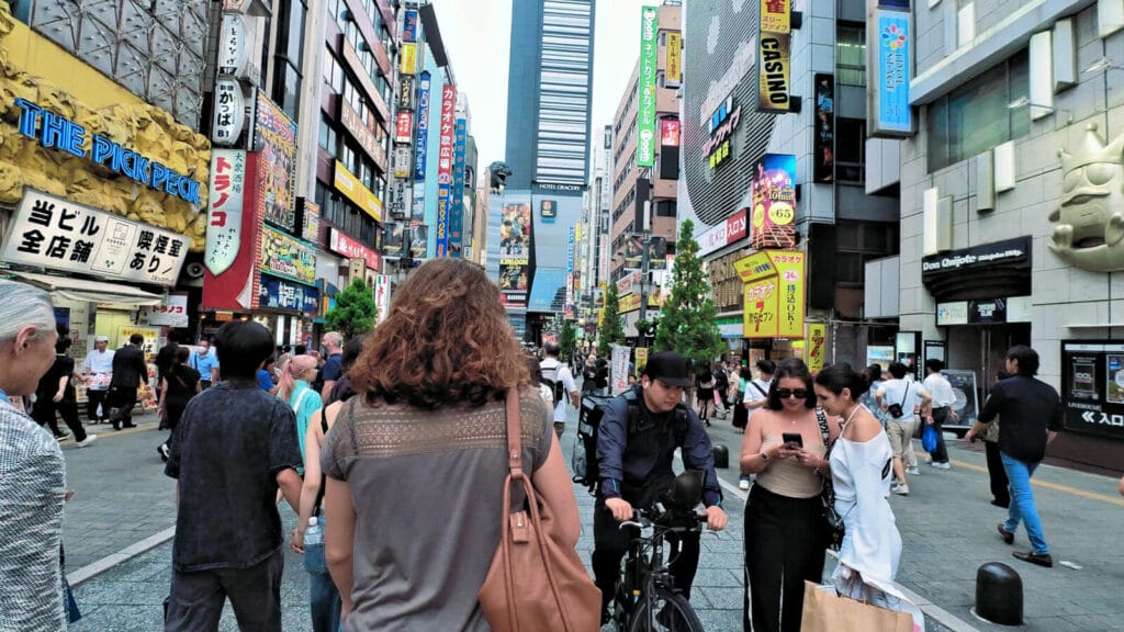 People walking at Kabukicho Shinjuku in the evening. You can see the Godzilla head.